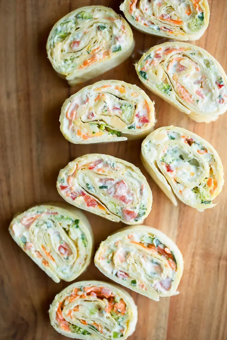 Fun little pinwheel sandwich bites are made up of a mix of colorful veggies, cream cheese, and tortilla wraps. These creamy, cheesy mayo roll-ups, flavored with black pepper, cheddar cheese, and dried dill leaves, are perfect as a party appetizer or a lunch box snack.