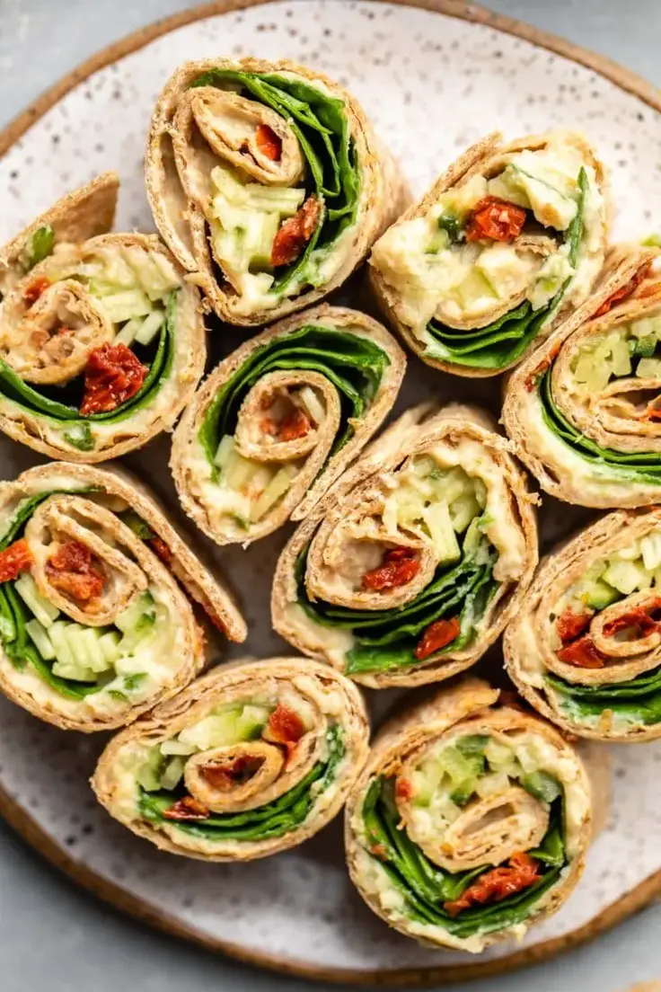 Hummus Pinwheel Appetizers with Cucumber & Sun-dried Tomatoes takes just 15 minutes to put together and 5 ingredients. Great recipe for a quick lunch, appetizer, or snack. 