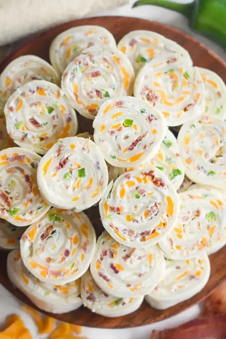 These Jalapeno Popper Pinwheel Appetizers are packed with cream cheese, crispy bacon, spicy jalapenos, cheddar cheese, and a hint of garlic powder, all wrapped in a tortilla. 