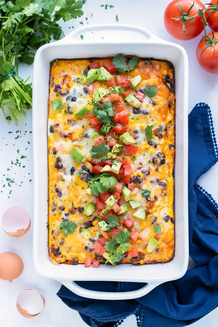 Mexican Breakfast Casserole by Evolving Tables is made up of layers of ground taco meat, fluffy eggs, fresh spicy salsa, corn, and cheese. 
